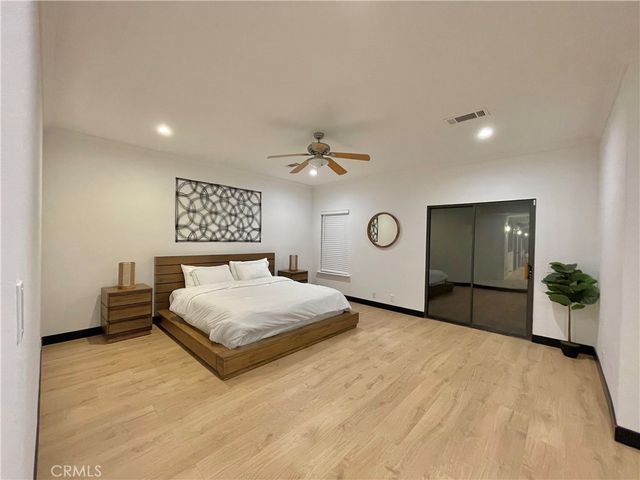 a spacious bedroom with a bed and a chandelier