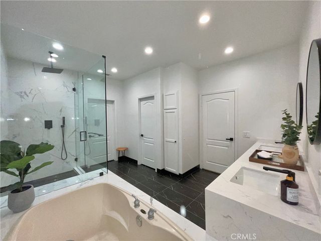 a bathroom with a tub a sink and mirror