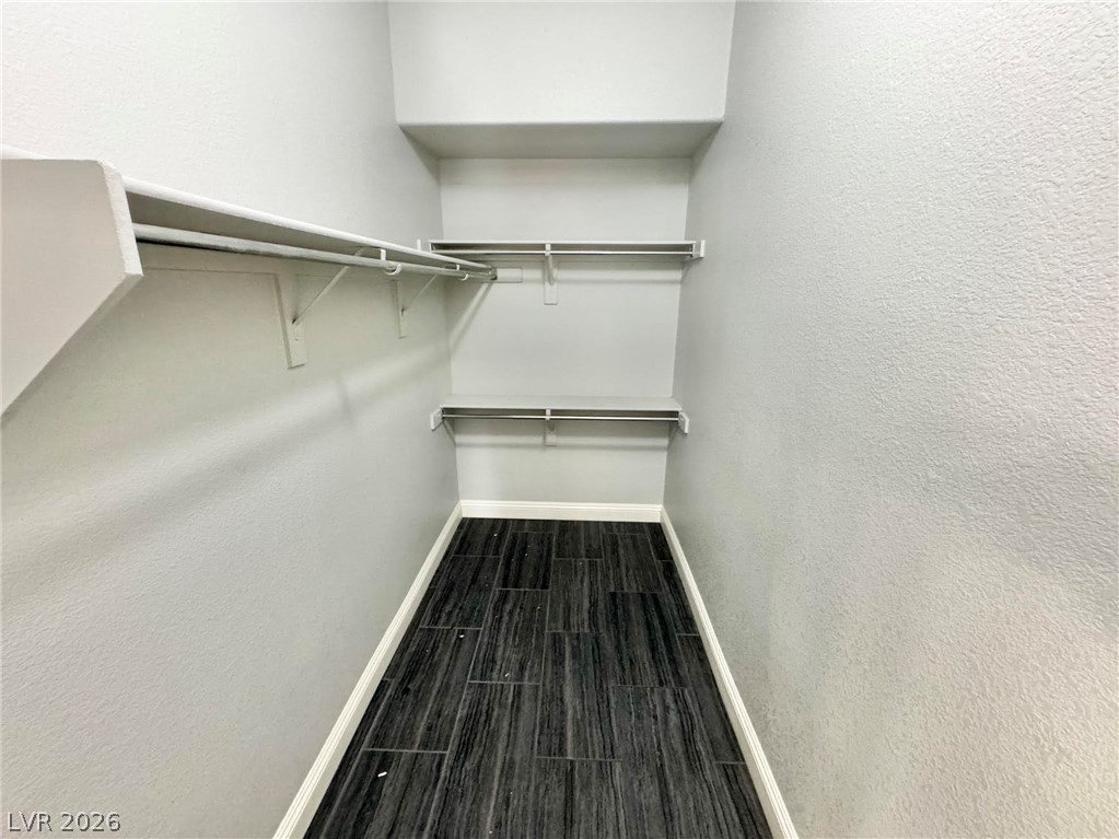 5304 Runningbrook Road Las Vegas, NV 89120 - Photo 11 of 22 Ample storage options await in this walk-in closet featuring durable dark tile flooring.