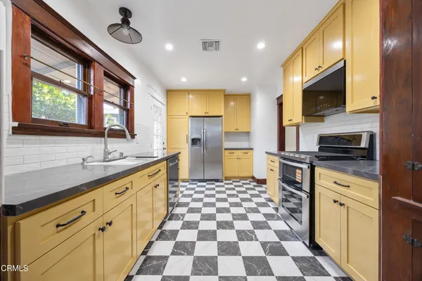 a kitchen with stainless steel appliances granite countertop a sink stove and microwave
