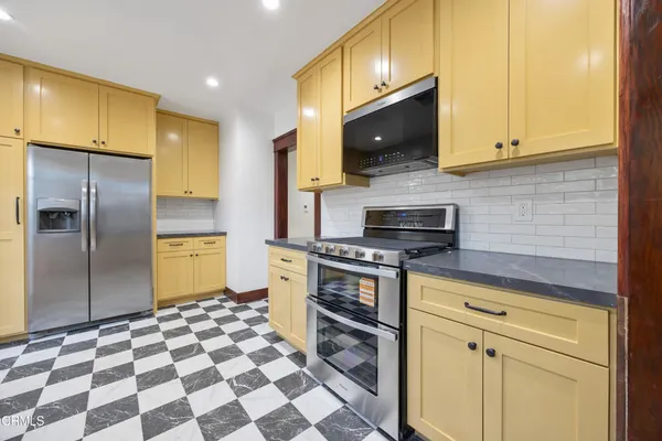 a kitchen with stainless steel appliances a stove a microwave and a refrigerator
