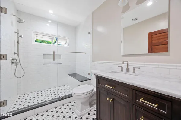 a bathroom with a granite countertop sink toilet and shower