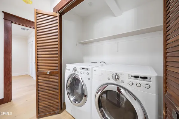 a view of washer and dryer with kitchen in the background