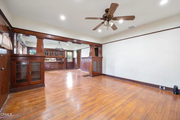 a view of a room with wooden floor and chandelier