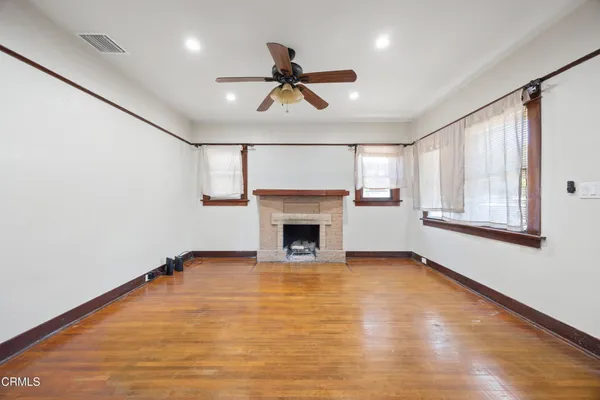 a view of empty room with wooden floor and fireplace