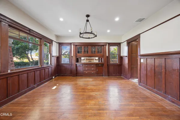 a view of an entryway with wooden floor door windows and a chandelier