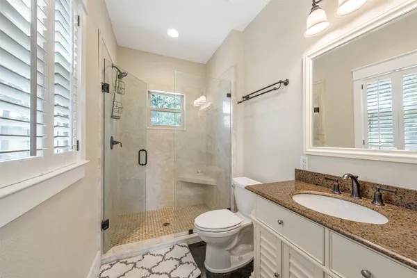 a bathroom with a granite countertop sink toilet and shower