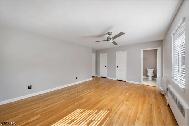 a big room with wooden floor and windows