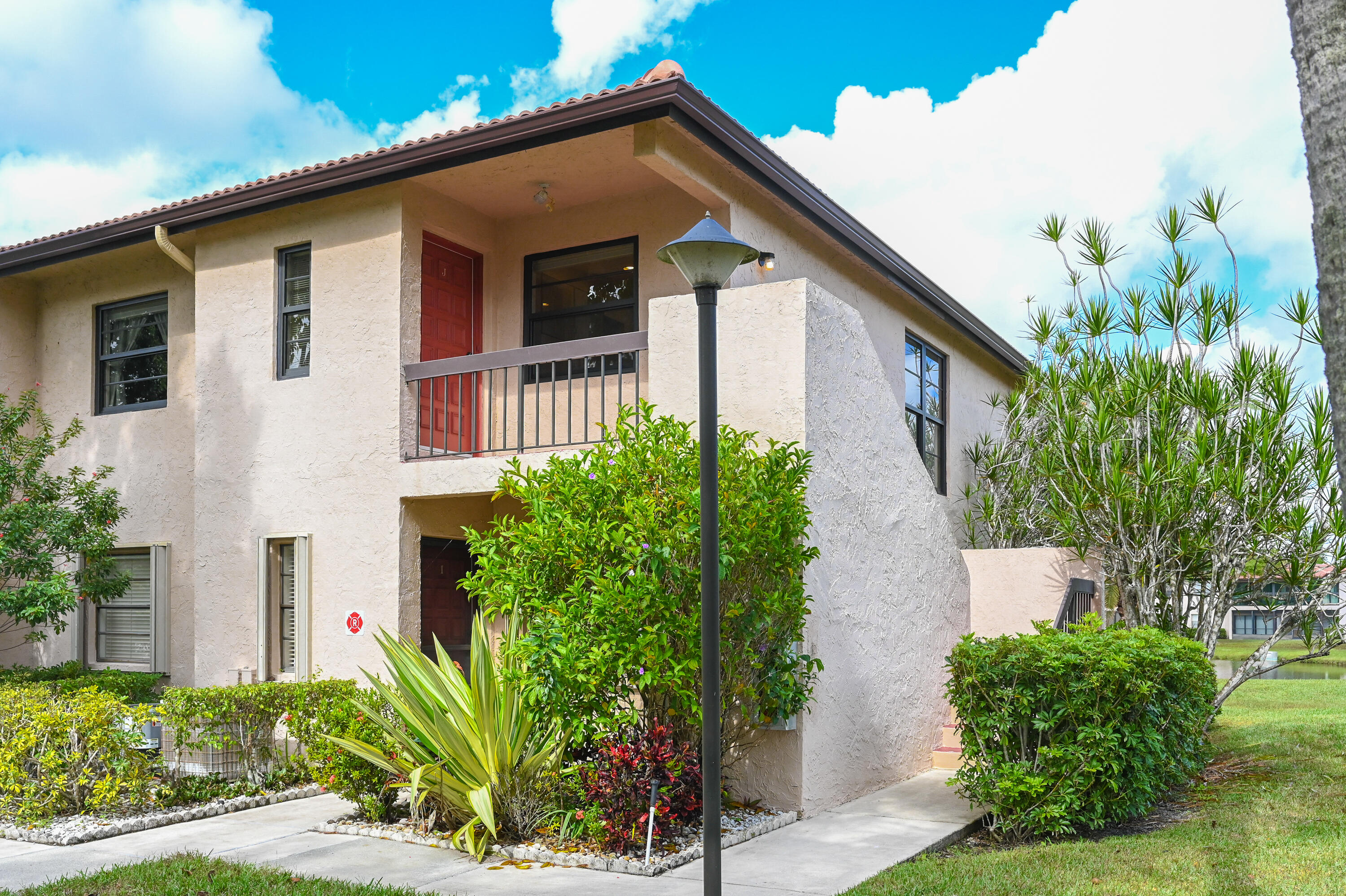 9259 Vista Del Lago, Unit 18J Boca Raton, FL 33428 - Photo 25 of 37 a front view of a house with garden