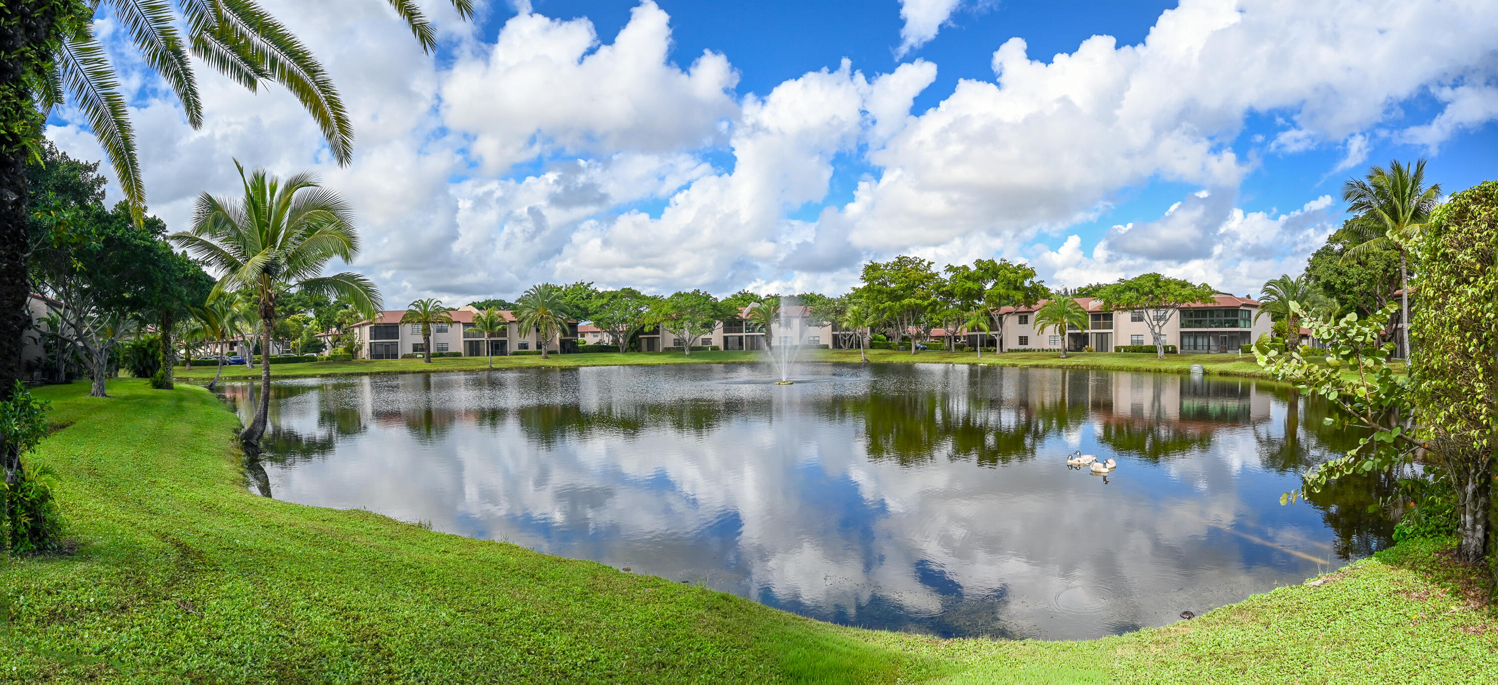 9259 Vista Del Lago, Unit 18J Boca Raton, FL 33428 - Photo 27 of 37 a view of a lake with a house in the background