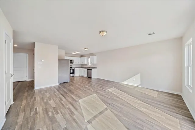 a view of empty room with wooden floor