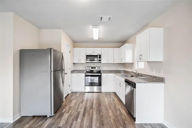 a kitchen with stainless steel appliances granite countertop a stove a refrigerator and a refrigerator