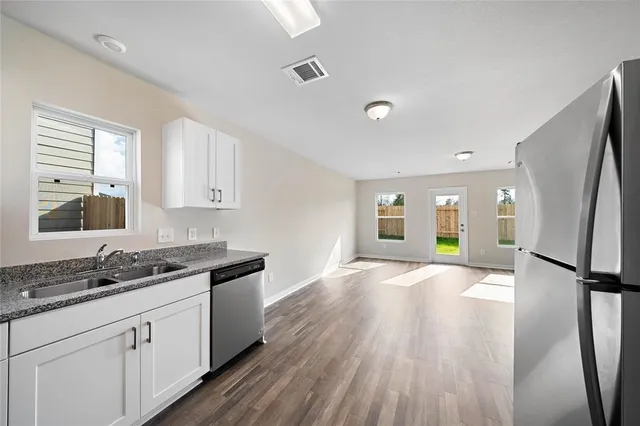 a kitchen with granite countertop a stove a sink and a refrigerator
