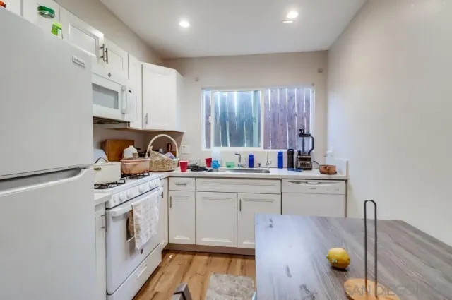 a kitchen with a sink cabinets and wooden floor