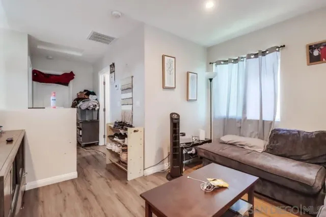 a living room with furniture a wooden floor and a large window