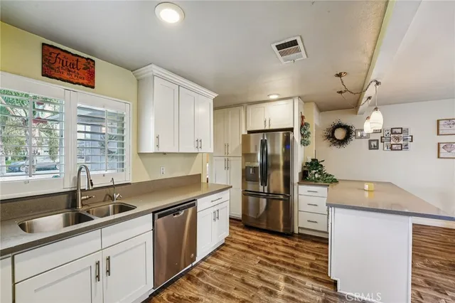 a kitchen with stainless steel appliances granite countertop a refrigerator and a sink