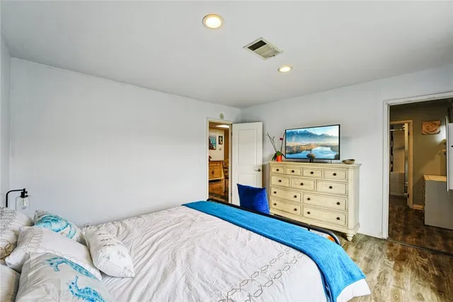 a bedroom with a bed and a flat tv screen on dresser