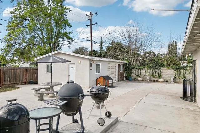 a view of a patio with table and chairs under an umbrella