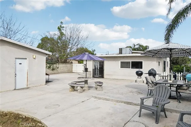 a backyard of a house with table and chairs