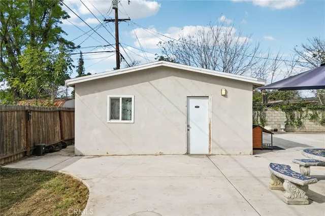 a view of backyard with seating space and wooden fence