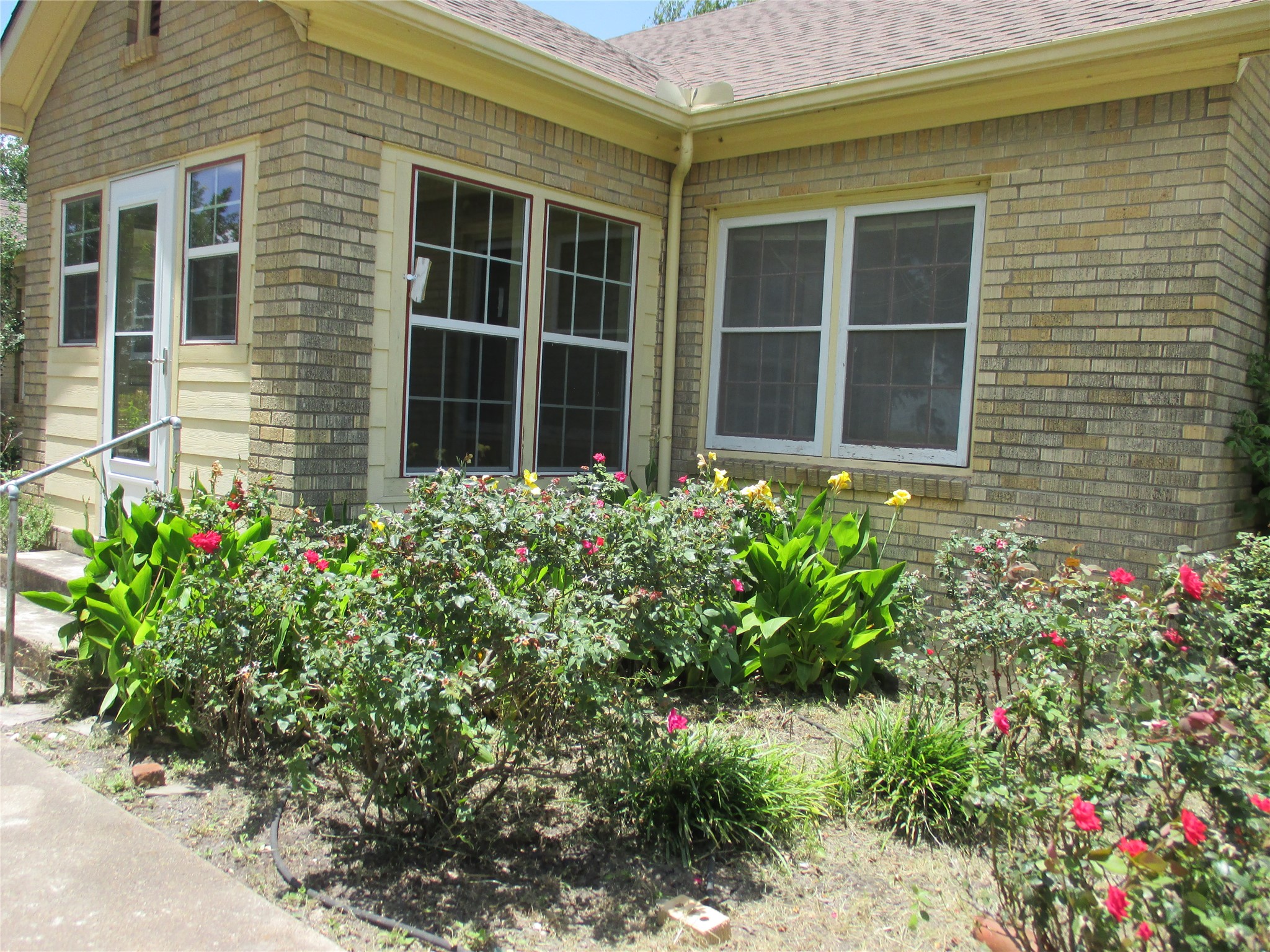12610 Pecan School Road Bartlett, TX 76511 - Photo 20 of 21 A vibrant garden bursting with colorful blooms adorns the front of this brick residence.