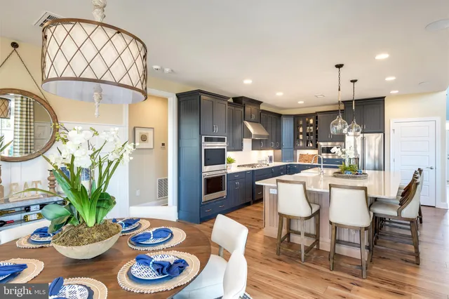 a kitchen with granite countertop stainless steel appliances a dining table and chairs