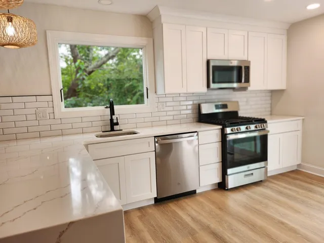 a kitchen with a sink stove top oven and cabinets
