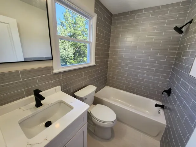 a bathroom with a toilet a sink and mirror