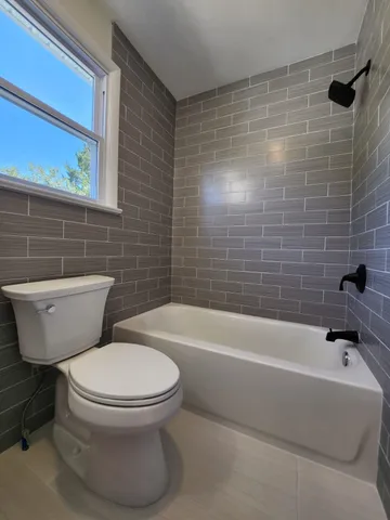 a bath room with a toilet and a bath tub