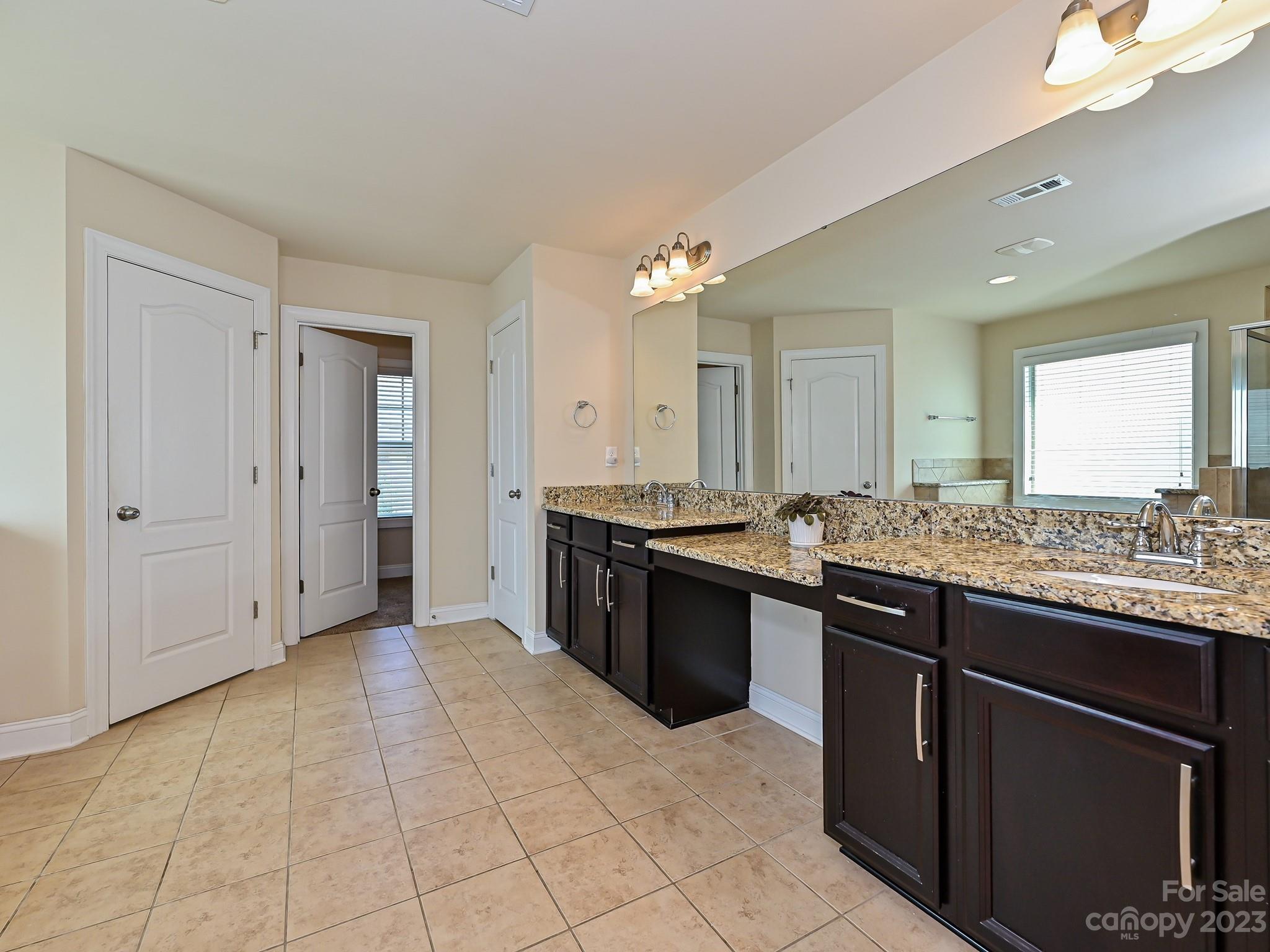 1012 Thorndale Road Indian Trail, NC 28079 - Photo 23 of 36 a large bathroom with a granite countertop double vanity sink a mirror and a shower