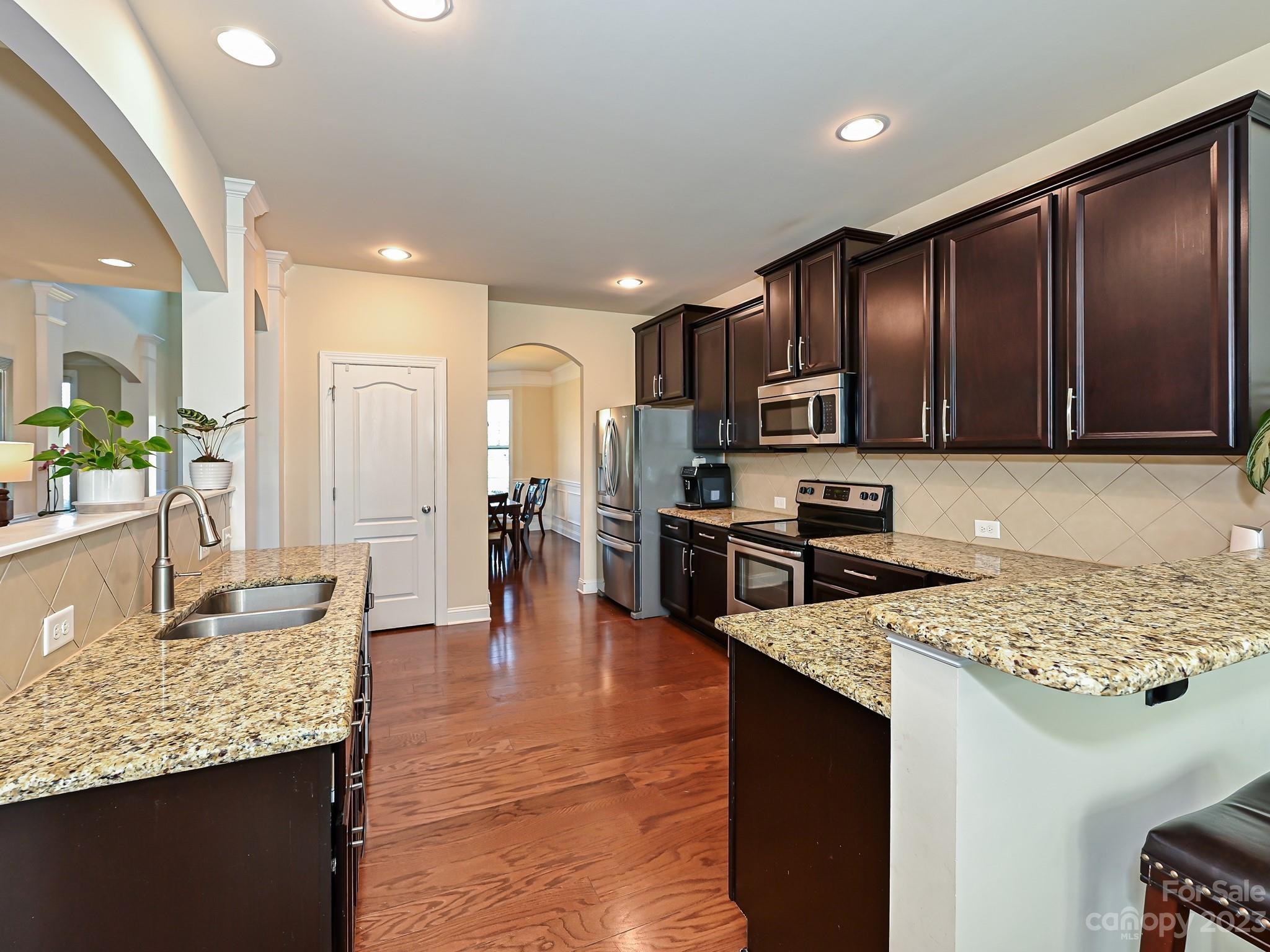 1012 Thorndale Road Indian Trail, NC 28079 - Photo 10 of 36 a kitchen with granite countertop stainless steel appliances and wooden cabinets