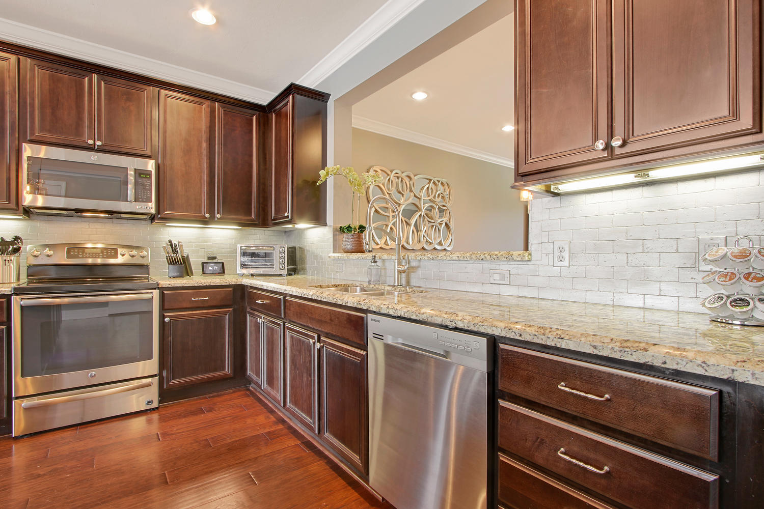 2706 Avalon Way Jupiter, FL 33458 - Photo 6 of 28 a kitchen with granite countertop wooden cabinets stainless steel appliances and a counter space