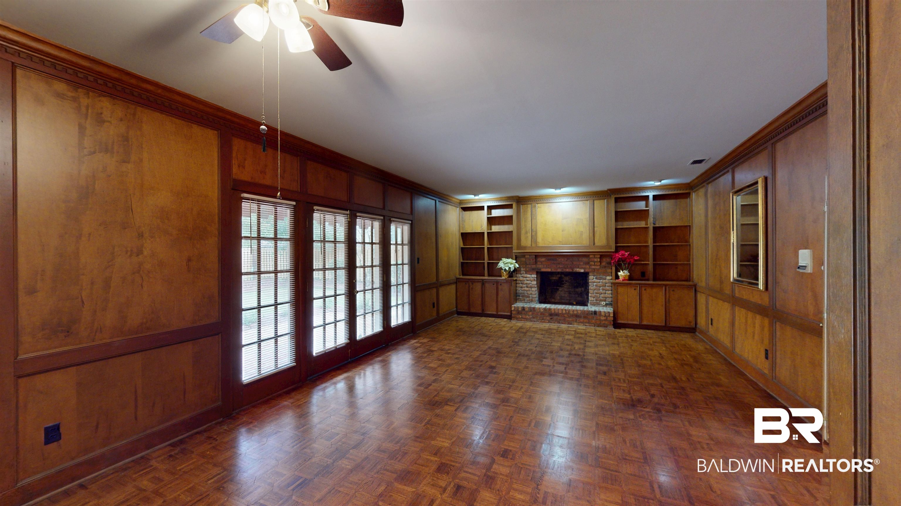 53 Warwick Road Mobile, AL 36608 - Photo 20 of 45 Den featuring built in features, wooden walls, crown molding, a brick fireplace, and ceiling fan