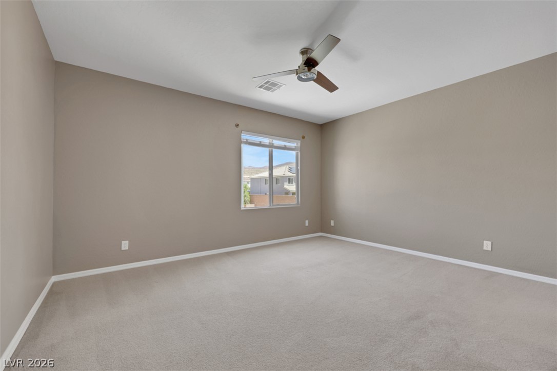 2501 Bechamel Place Henderson, NV 89044 - Photo 32 of 50 A spacious, airy bedroom offers comfortable carpeting and a modern ceiling fan for year-round comfort.