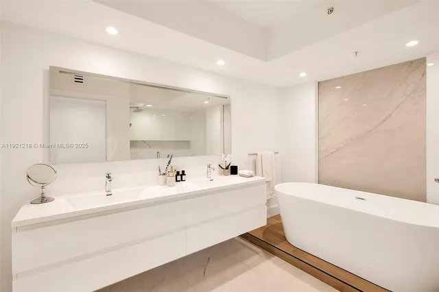 a bathroom with a sink a toilet and a large mirror