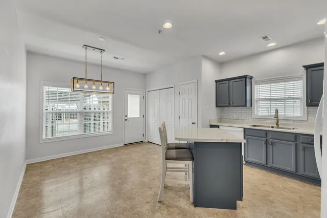 a large kitchen with kitchen island a sink stainless steel appliances and cabinets