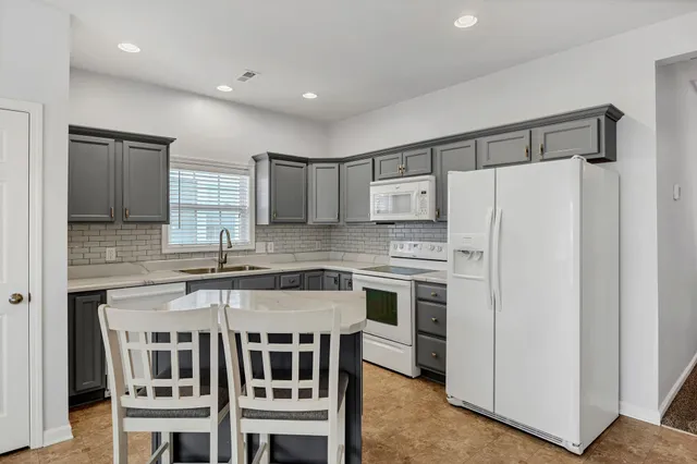 a kitchen with stainless steel appliances a stove a sink and a refrigerator