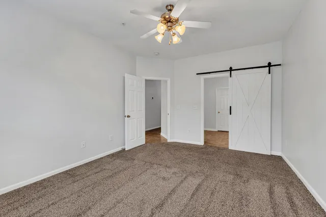 a view of a big room with chandelier fan and closet area