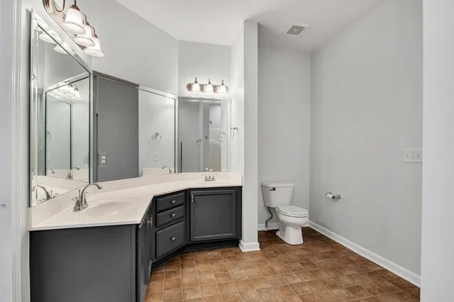 a bathroom with a double vanity sink toilet and a mirror