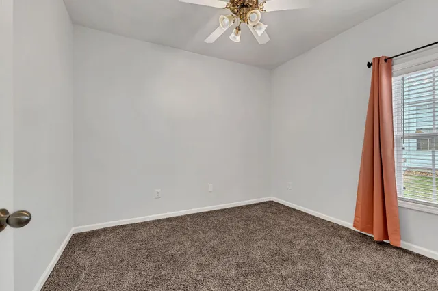 an empty room with a chandelier fan
