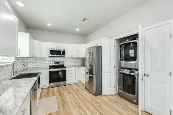 a kitchen with stainless steel appliances granite countertop a refrigerator stove and sink