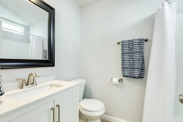 a bathroom with a sink a toilet and a mirror