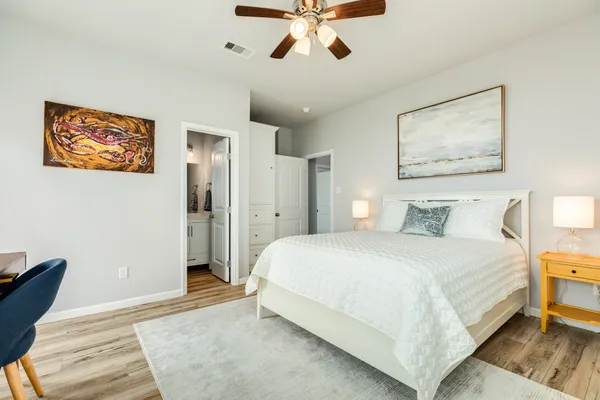 a bedroom with a large bed and a chandelier