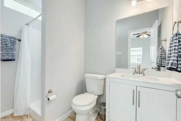a bathroom with a toilet sink vanity and mirror