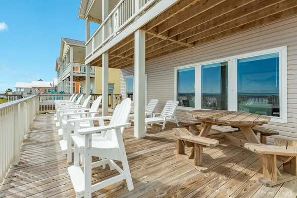 a view of a patio with table and chairs with wooden floor and fence
