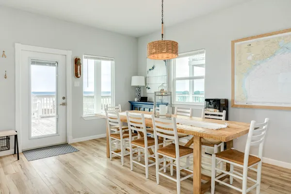 a dining room with furniture a chandelier and wooden floor