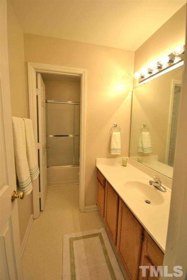 2908 Englefield Drive Raleigh, NC 27615 - Photo 11 of 16 a bathroom with a granite countertop sink mirror and shower