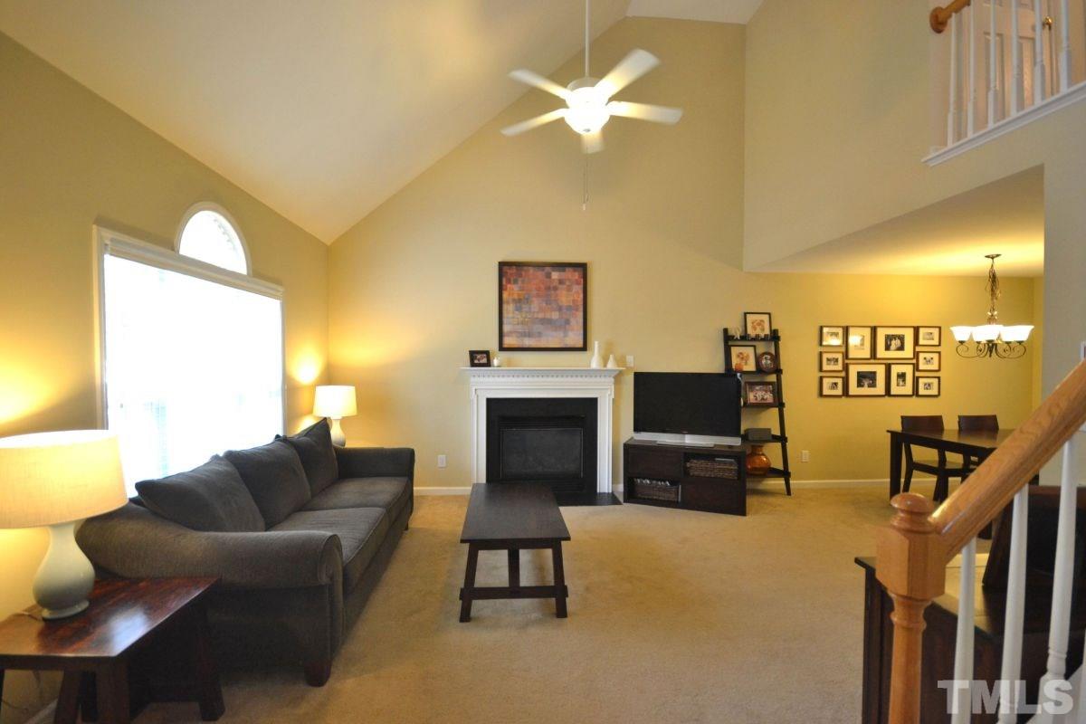 2908 Englefield Drive Raleigh, NC 27615 - Photo 2 of 16 a living room with furniture a fireplace and a flat screen tv