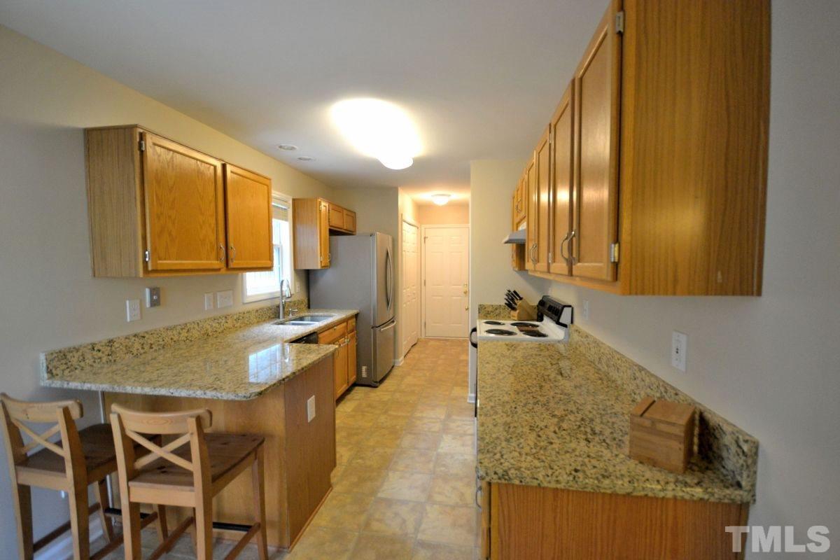 2908 Englefield Drive Raleigh, NC 27615 - Photo 4 of 16 a kitchen with granite countertop sink and cabinets