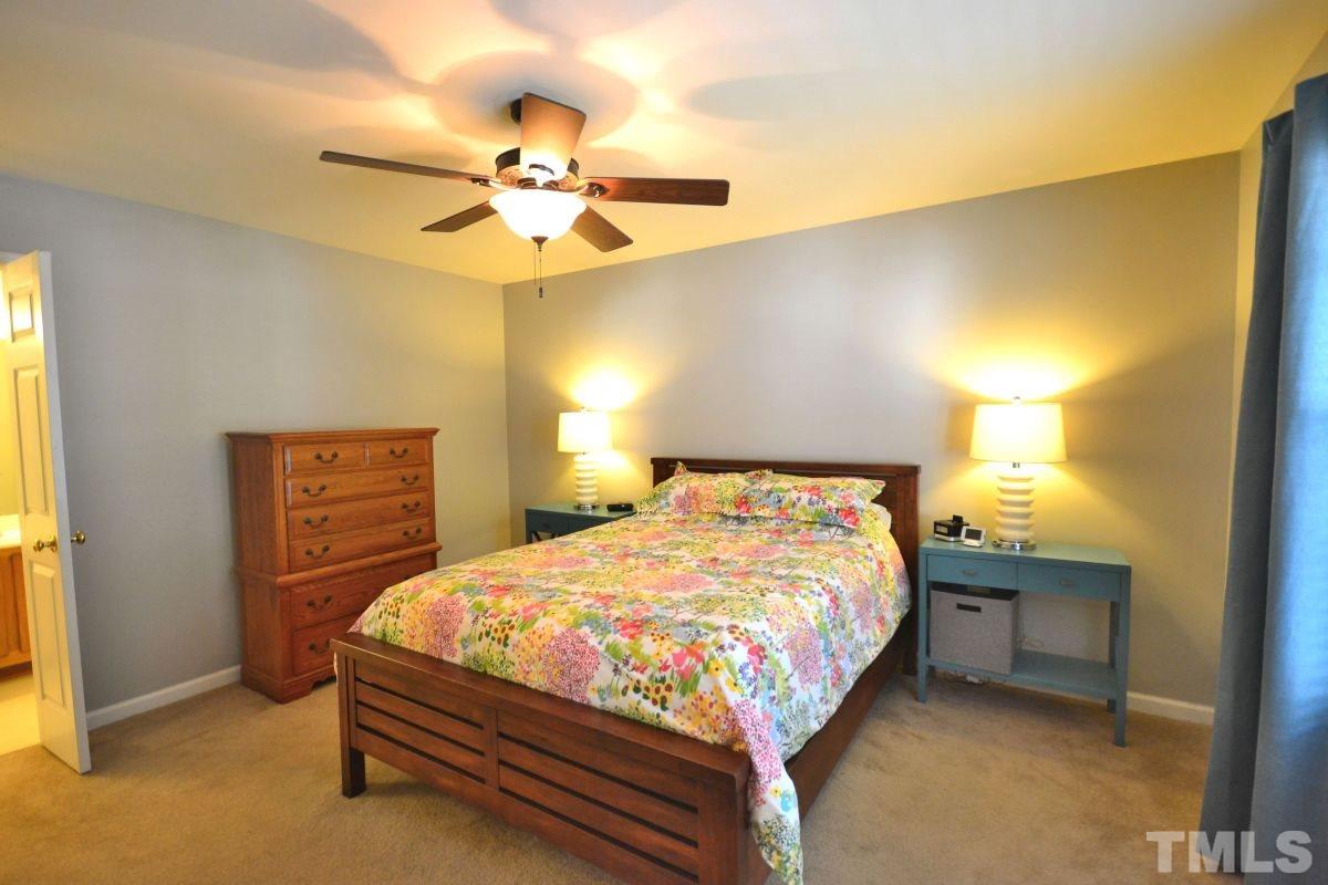 2908 Englefield Drive Raleigh, NC 27615 - Photo 5 of 16 a bedroom with a bed and a lamp with paintings on the wall